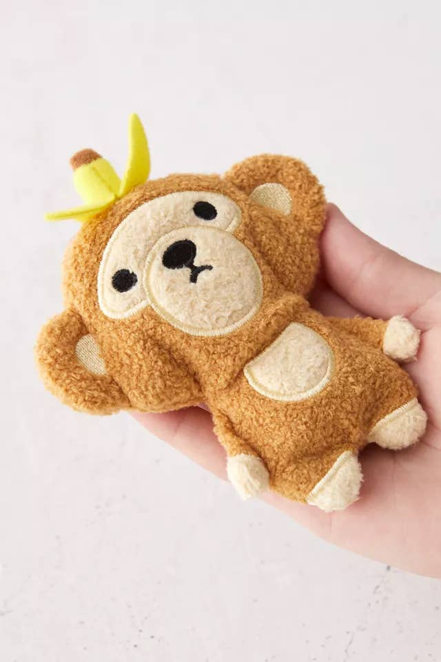 a hand holding a monkey plushie