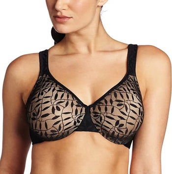 a model wearing a sheer black bra with a leaf-pattern overlay