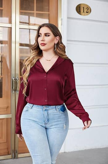 Model in a burgundy blouse and light blue jeans