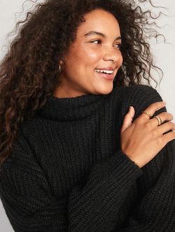 another model in a black turtleneck sweater with the neck folded down