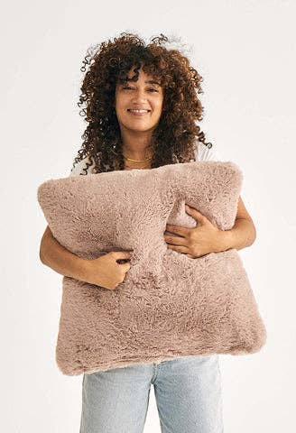 large fuzzy square pillow in model's arms 