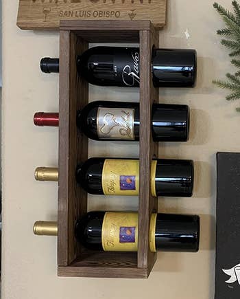 Reviewer image of the wooden rack with four bottles 