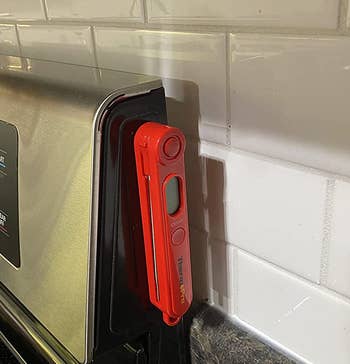 reviewer photo showing the magnetic food thermometer attached to the side of a stove
