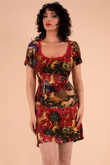 model in a short patterned dress with medieval tapestry design, scoop neck, and short sleeves
