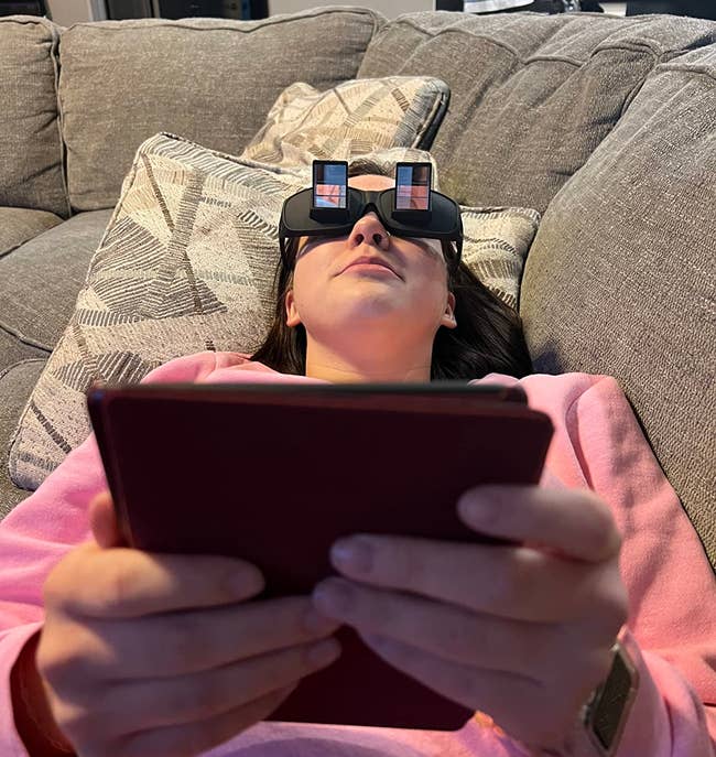 reviewer wearing the glasses while reading from a handheld reader device