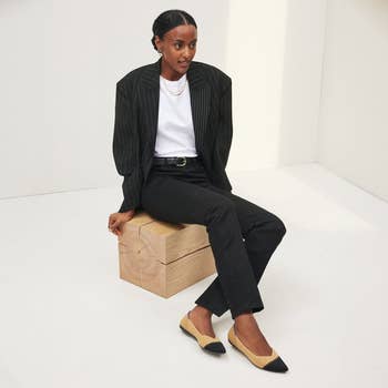 model wearing the tan flats with black toe