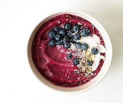 a smoothie bowl with blueberries and shaved coconut