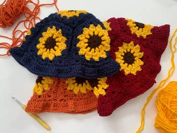 Product in blue, orange, and red next to yellow and orange yarn