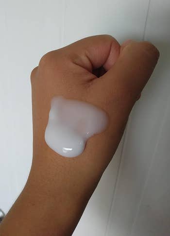 reviewer with the white cleanser on their hand