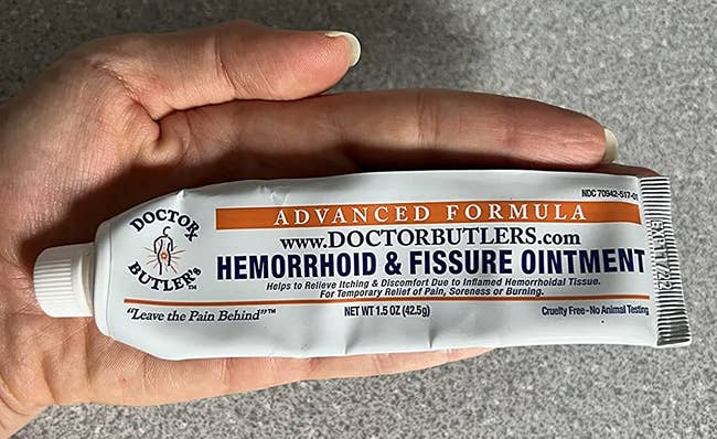 reviewer holding tube of hemorrhoid cream