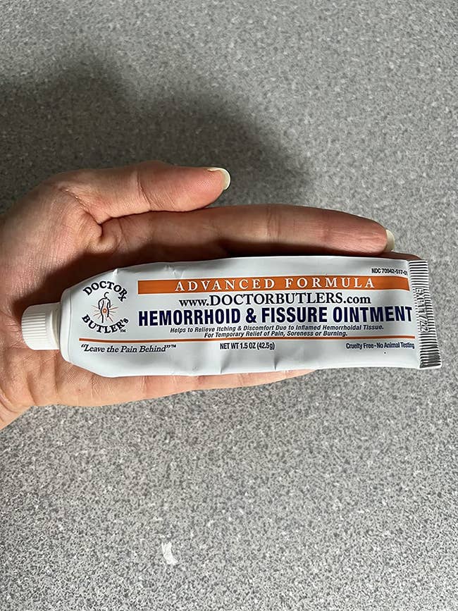 reviewer holding tube of hemorrhoid cream