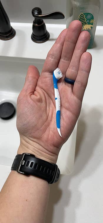 Reviewer holding one of the disposable toothbrushes in their hand