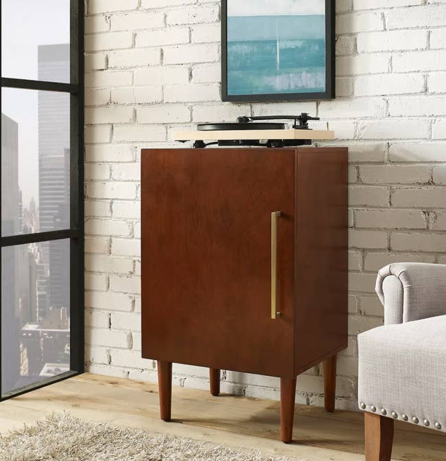 a media cabinet with a record player sitting on top