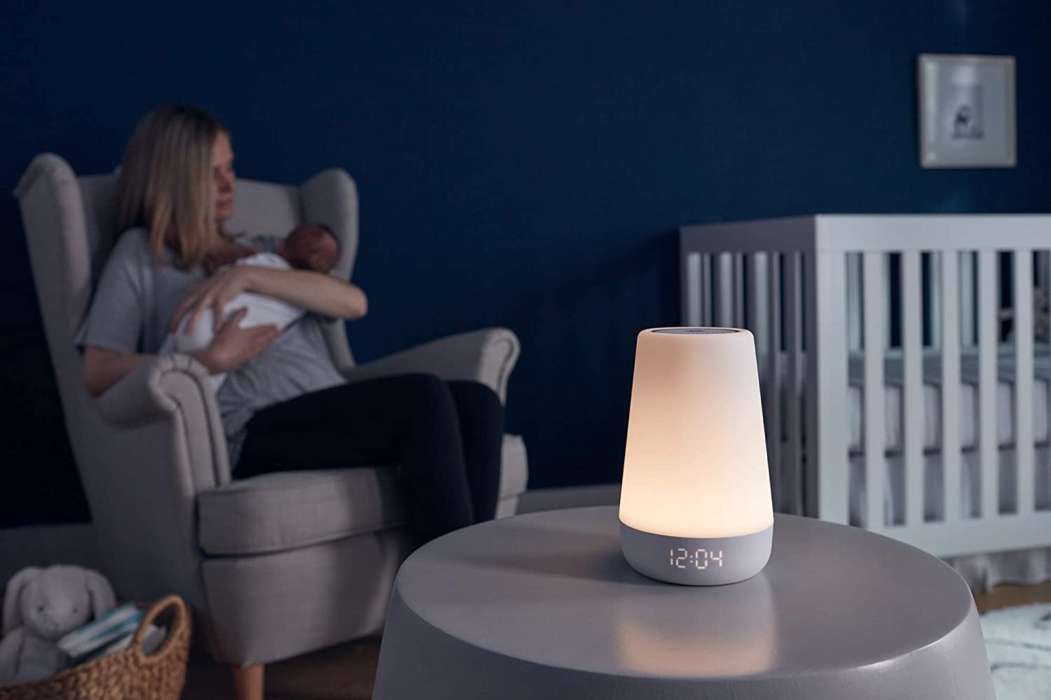 a mother cradling a baby in the background with the hatch gadget on a table in front of them