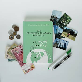 green book surrounded by photos and international money 