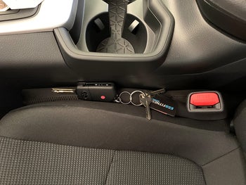 A reviewer's keys being stopped from falling between the seat from the gap fillers