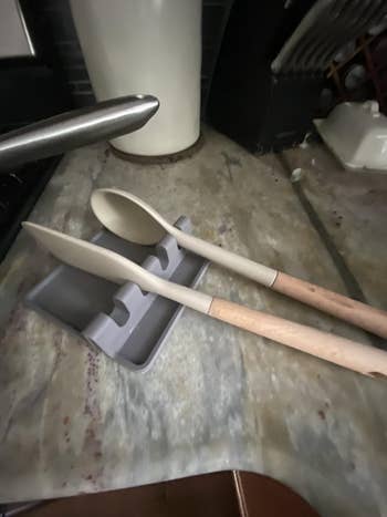 Wooden spoons with grey  silicone rests connected  a room  countertop, showcasing kitchenware organization