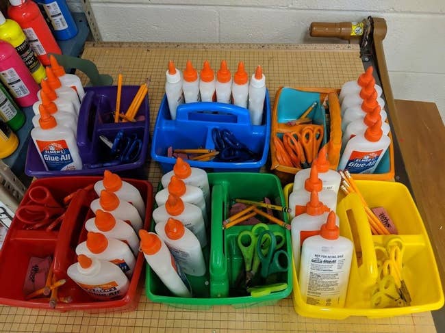 Various schoolhouse  supplies, including glue bottles, scissors, and pencils, are neatly organized successful  colorful containers connected  a table