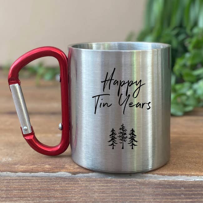 tin mug with carabiner handle. mug says happy tin years. 