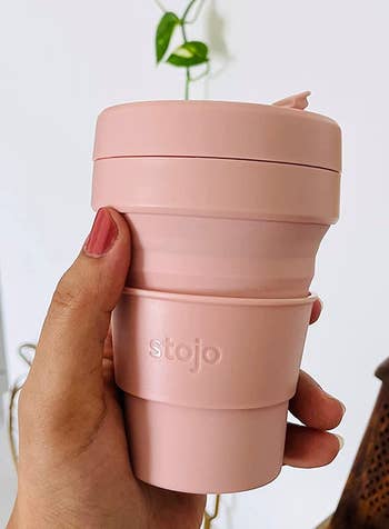 reviewer's small pink coffee cup with a lid 