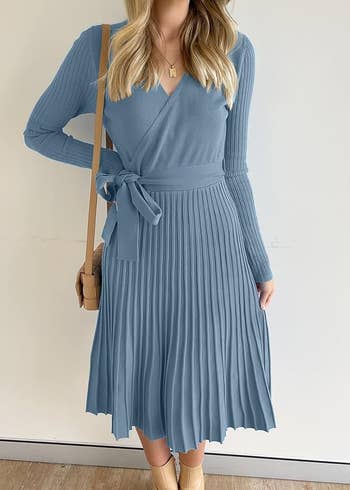 Model wearing a pleated wrapper  formal  with agelong  sleeves and a necktie  waist, 