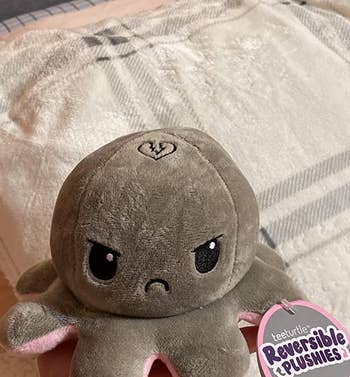 reviewer photo of a gray octopus plush with an angry face on it