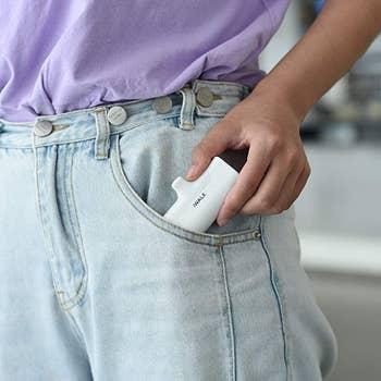 A model putting the charger in their pocket to show how small it is