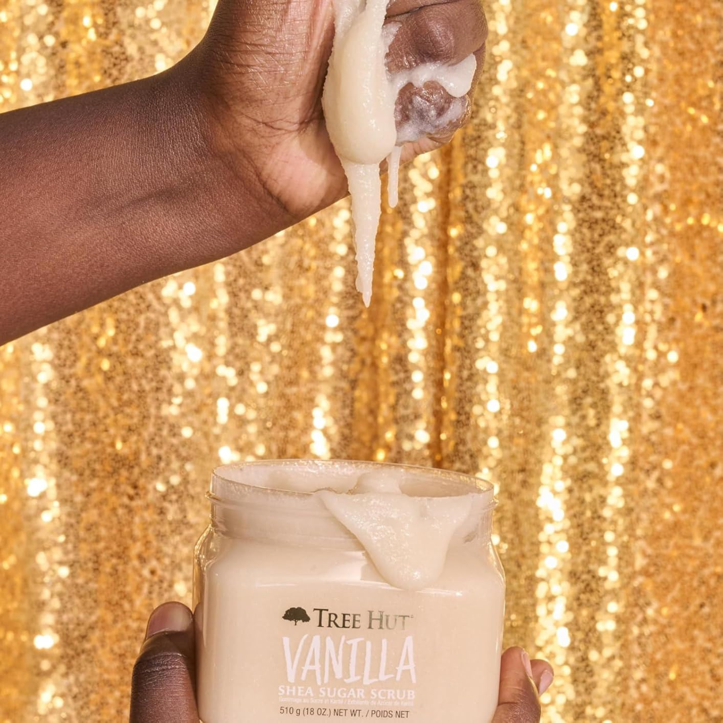 Person holding and scooping vanilla shea scrub 