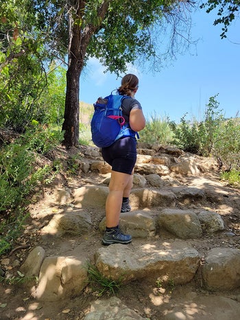 reviewer hiking up a rocky hill wearing the shorts in black