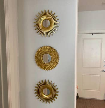 Reviewer image of three small mirrors with gold trim that look like sun rays 