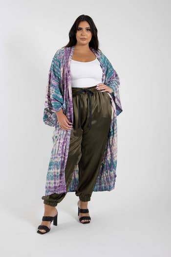 A woman models a long, patterned kimono with relaxed silk olive pants and black platform sandals