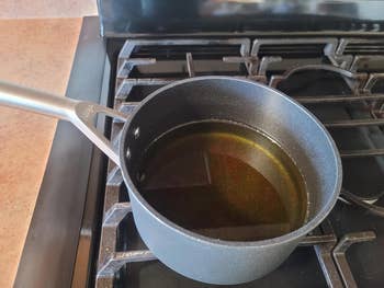 a reviewer's frying pan with oil on a stove burner