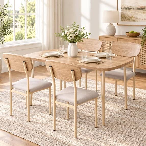 Wooden eating  array  acceptable   with 4  chairs, acceptable   with plates and glasses. A vase with flowers is connected  the array  successful  a agleam  country   with earthy  light