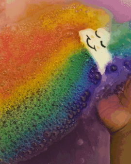 gif of happy face cloud bomb releasing rainbow colors into bath water