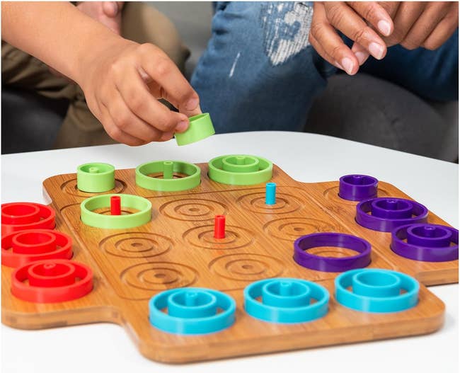 players playing otrio with 4 sets of ringing crippled pieces
