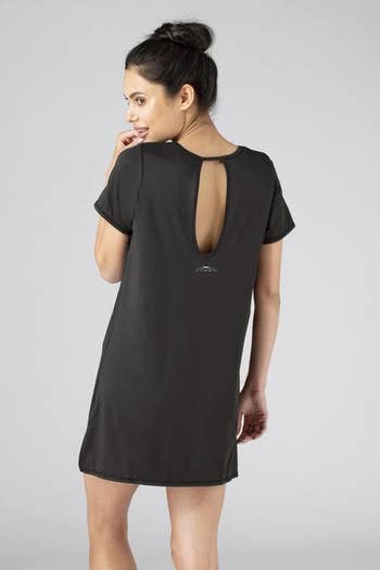back of model wearing the black sleep tee dress, showing the cutout at the top