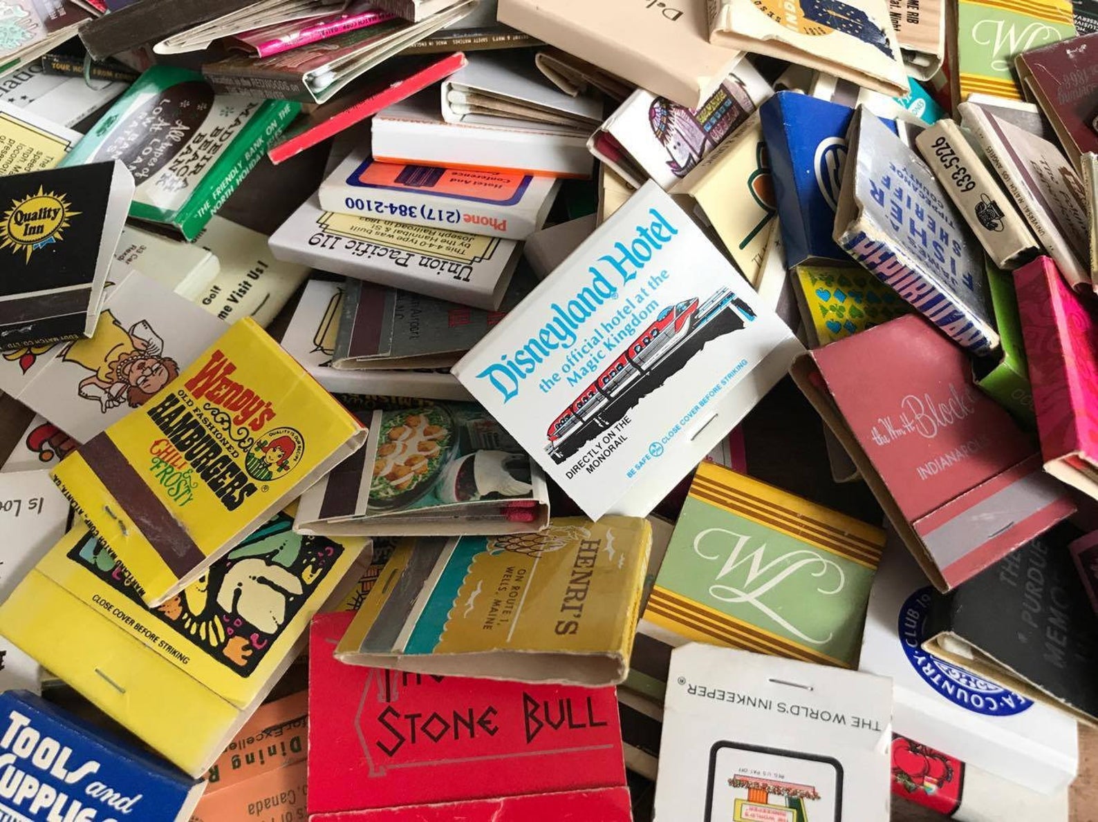a pile of vintage matchbooks from places like the Disneyland Hotel