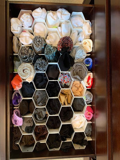 Drawer with various clothes organized in compartment dividers