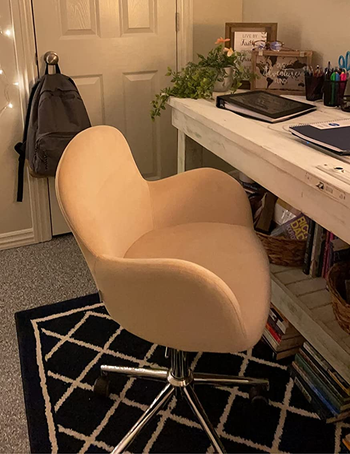 a reviewer photo of a pink velvet chair with winged arms 