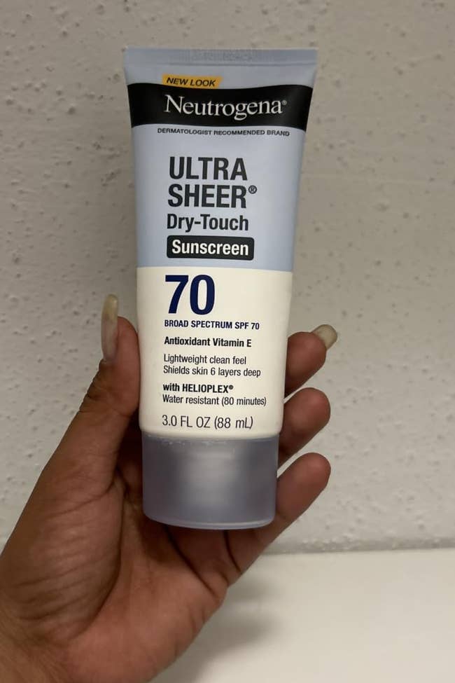 Hand holding Neutrogena Ultra Sheer Dry-Touch Sunscreen SPF 70, showcasing its size for a buying article