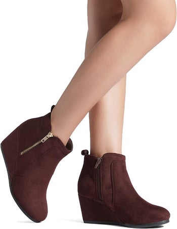 a model walking in brown suede wedge booties