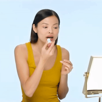 model applying the stick to their lips, then showing their face after it's been applied to their eyelids, cheeks, and lips