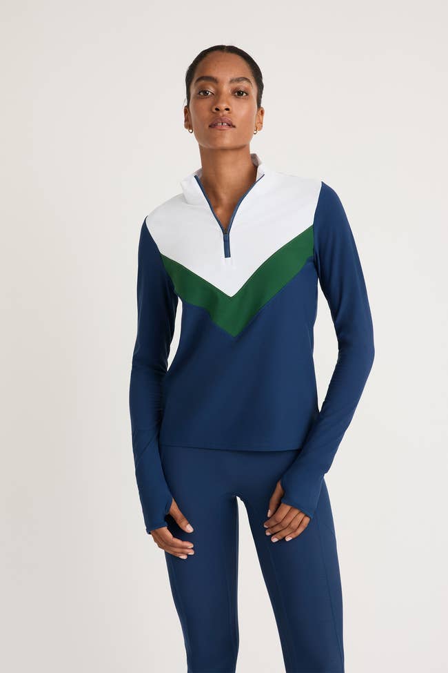 model wearing the quarter zip in blue, green, and white