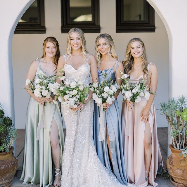 a bride with bridesmaids wearing the gown in green, blue, and pink.