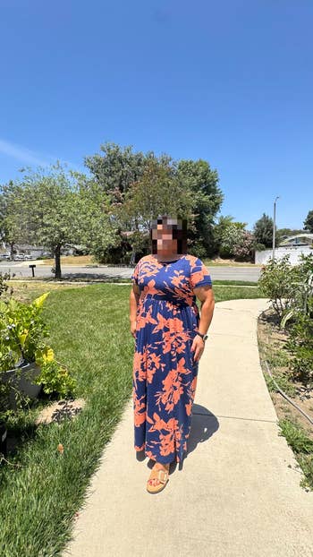 Woman successful a floral signifier formal stands outdoors connected a walkway, showcasing relaxed summertime fashion