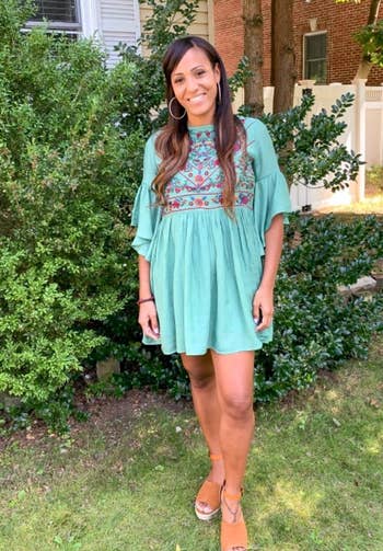 a reviewer wearing the sage embroidered dress