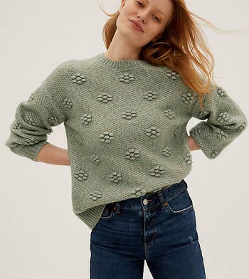 a model wearing the sweater in sage green 