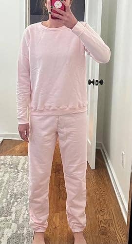Person wearing a comfy matching lounge set, taking a reflector selfie successful a casual setting