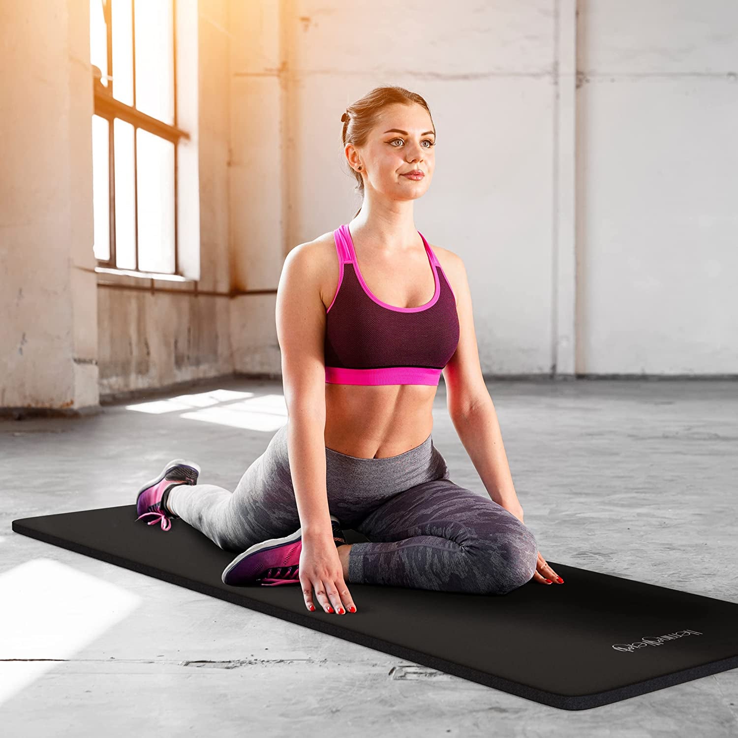 model stretches on cushioned black exercise mat