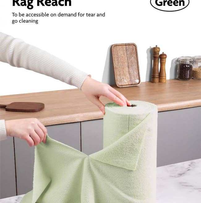 model pulling a light green tear off microfiber towel off a roll of them 